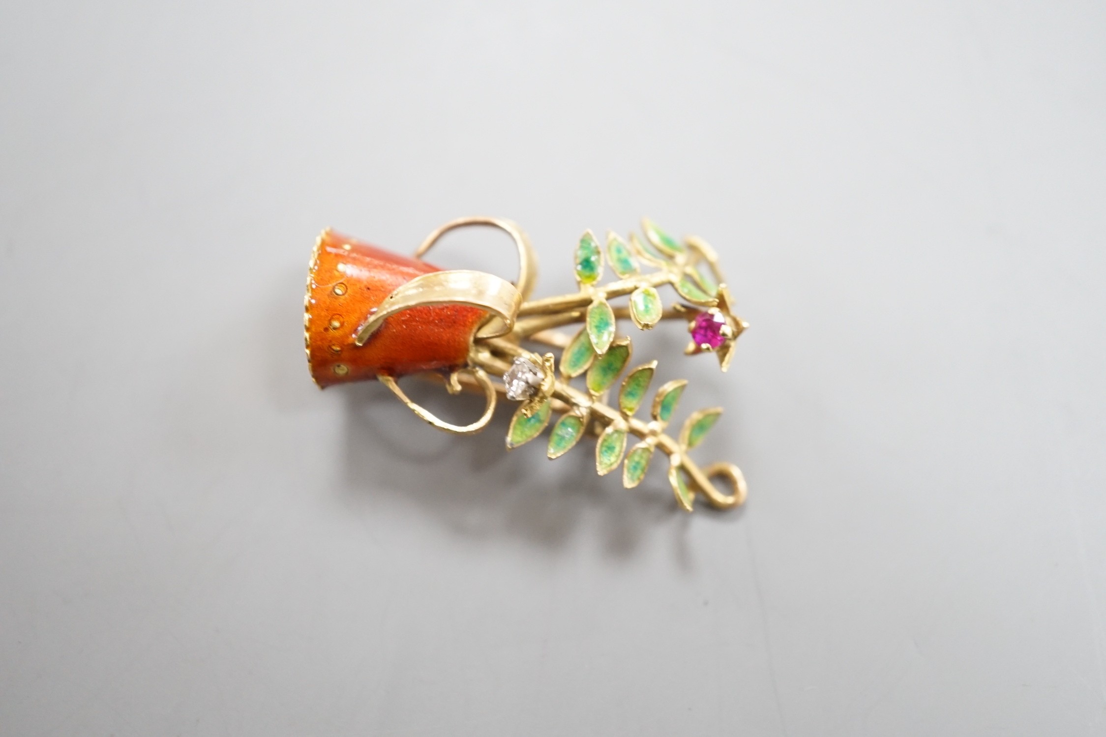 A French yellow metal (18ct poincon mark), two colour enamel, ruby and diamond set novelty brooch, modelled as a tyg with foliate stems, signed Marcel Pac, Paris, 29mm, gross weight 5.8 grams.